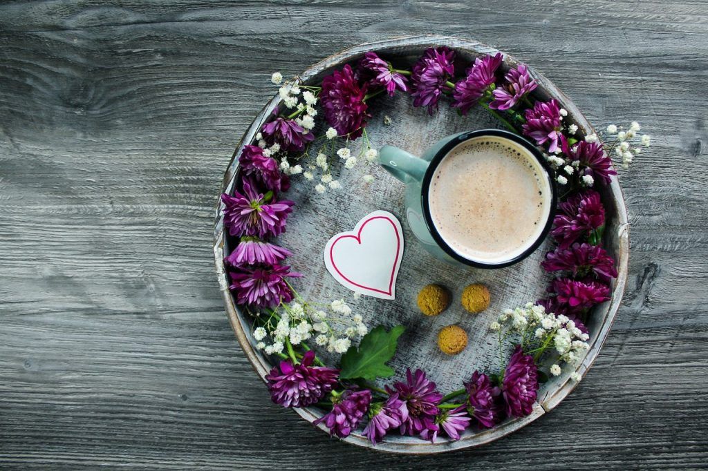Tablett mit Kaffeetasse, Keksen und Blumen
