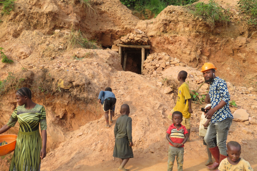 Kinder spielen vor dem eingang eines schlecht abgesichterten Eingangs zu einem Bergbau